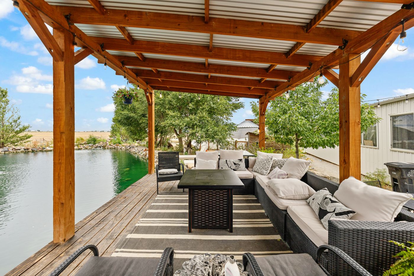 Outdoor couches under the timber pavilion beside the water