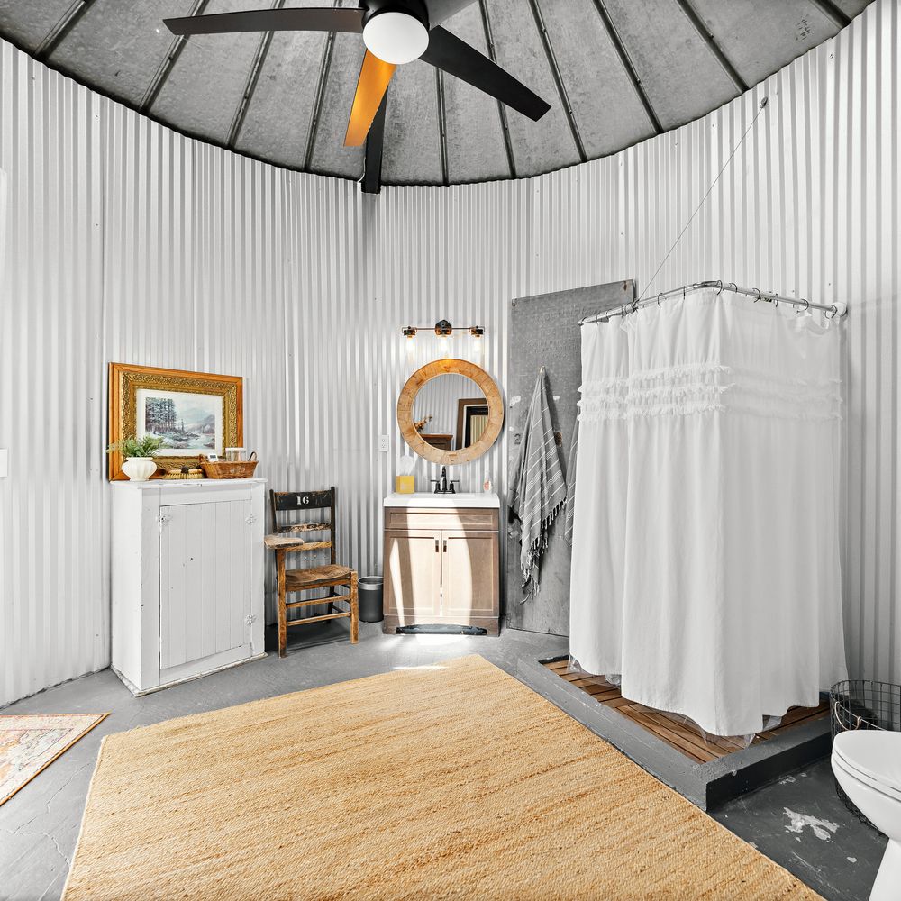 The silo bath — curved shower and ribbed steel walls under the domed ceiling