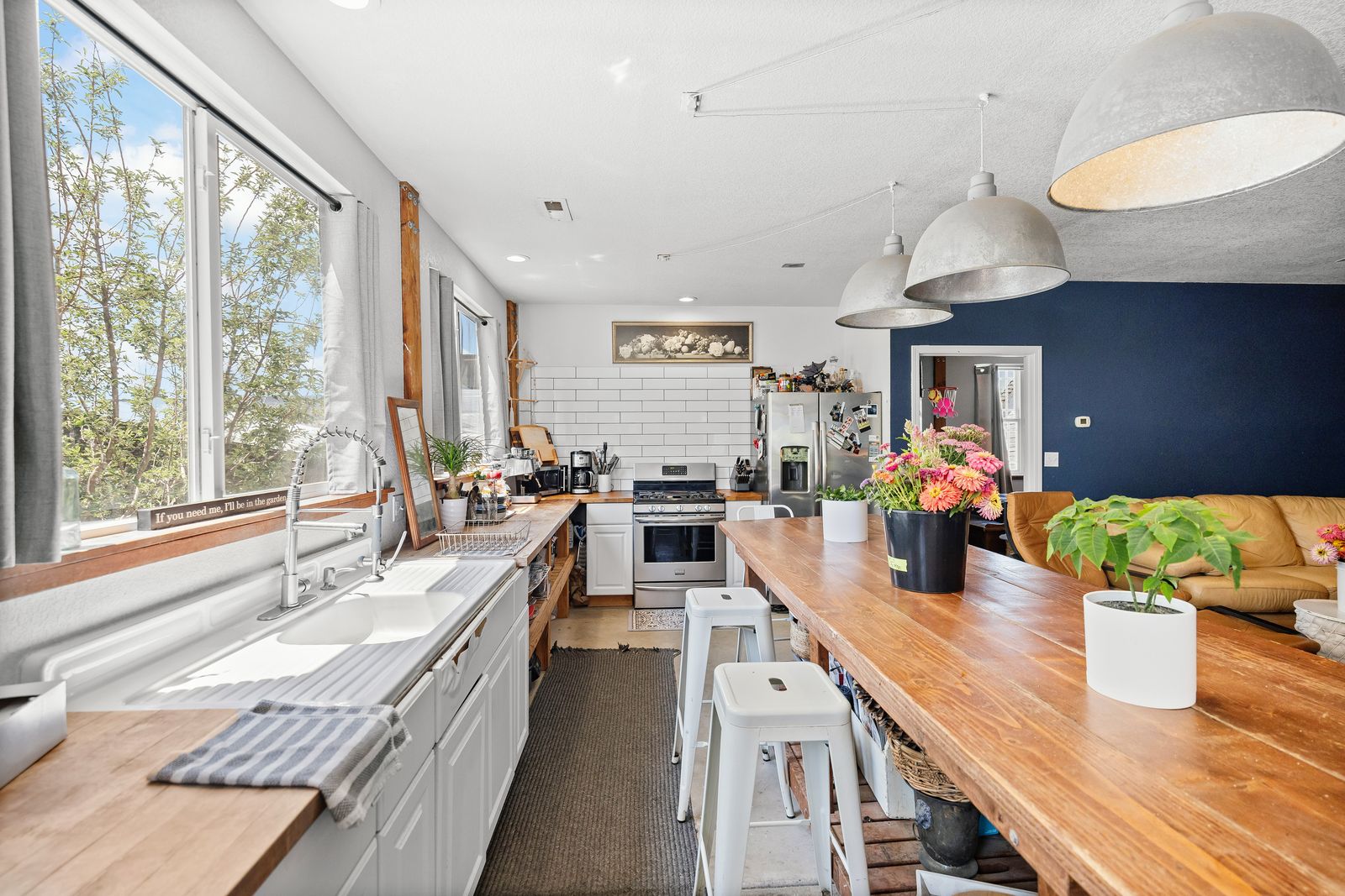 Inside the studio — one open room with long wood counters, farm sink, and big windows